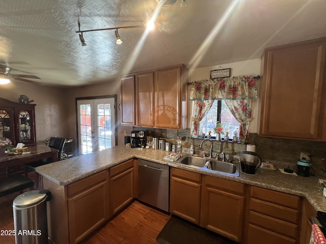 kitchen featuring kitchen peninsula, french doors, sink, hardwood / wood-style flooring, and dishwasher