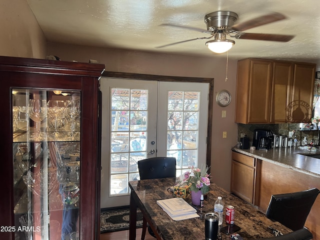 dining area with ceiling fan, french doors, and a textured ceiling