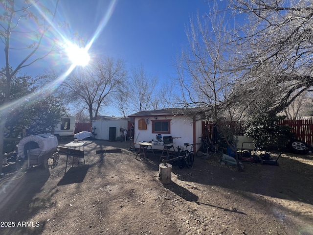 view of front of property featuring a storage shed