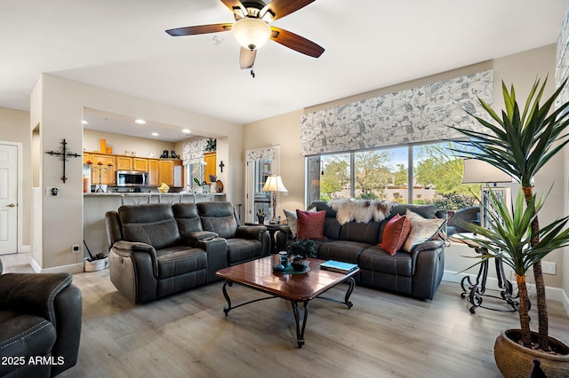 living room featuring ceiling fan and light hardwood / wood-style floors