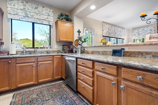 kitchen featuring sink, kitchen peninsula, and stainless steel dishwasher