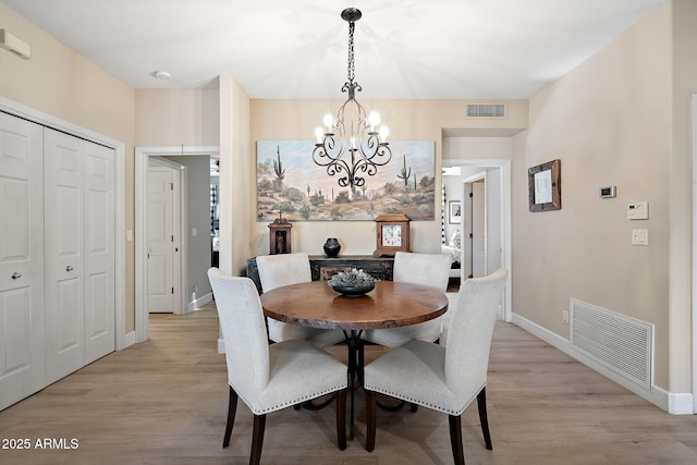 dining space featuring a chandelier and light hardwood / wood-style flooring