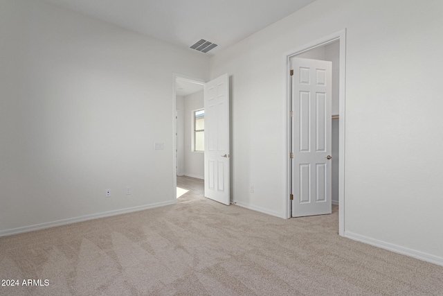 unfurnished bedroom featuring light carpet