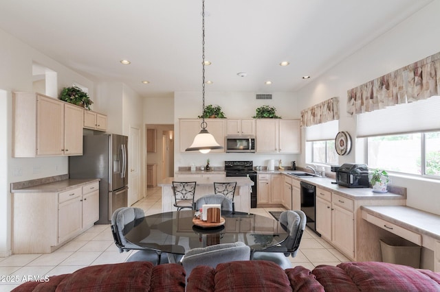 kitchen featuring black appliances, a sink, light tile patterned floors, light countertops, and open floor plan
