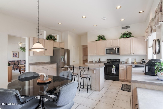 kitchen featuring stainless steel appliances, light countertops, light tile patterned flooring, a center island, and a breakfast bar