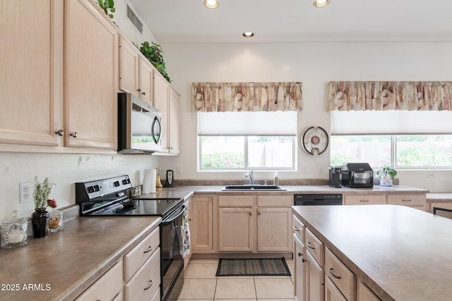 kitchen with stainless steel microwave, electric range, a sink, light brown cabinets, and healthy amount of natural light