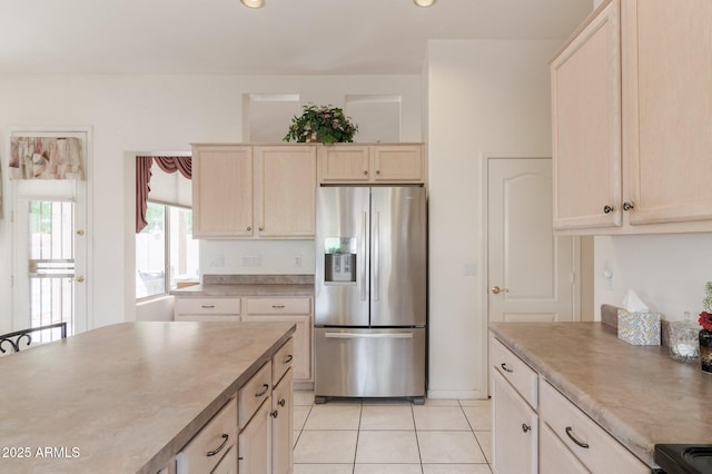 kitchen featuring stainless steel refrigerator with ice dispenser, light tile patterned floors, light countertops, range with electric cooktop, and recessed lighting