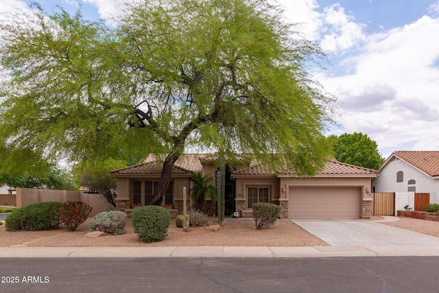 mediterranean / spanish-style house with stone siding, stucco siding, a garage, and driveway