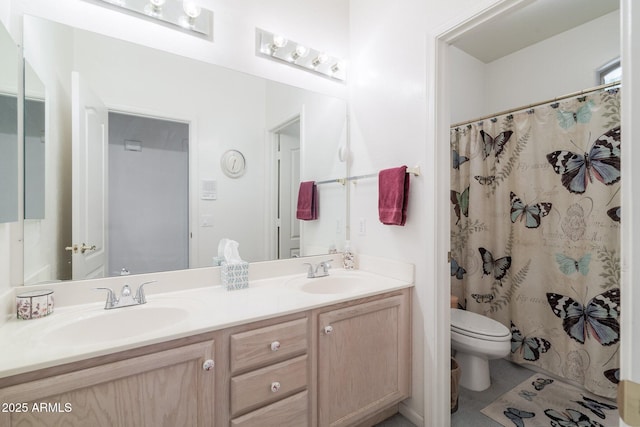 bathroom featuring toilet and double vanity