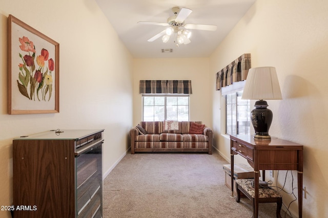 living room with carpet, a ceiling fan, and baseboards