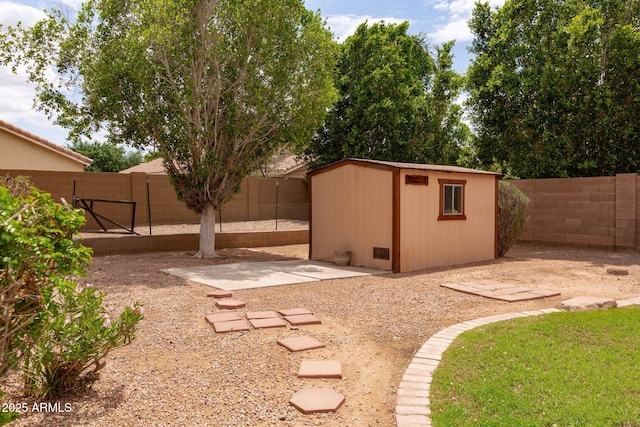 fenced backyard with an outdoor structure, a shed, and a patio