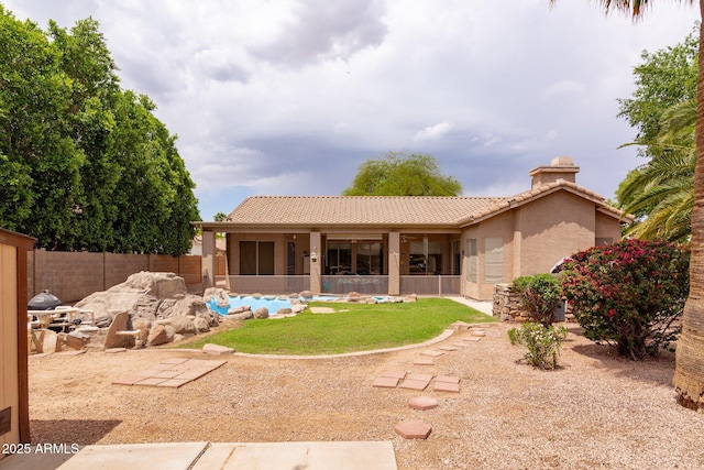 rear view of house with a tiled roof, stucco siding, fence, and a patio area