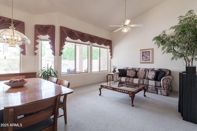 carpeted living room featuring a chandelier, ceiling fan, and vaulted ceiling