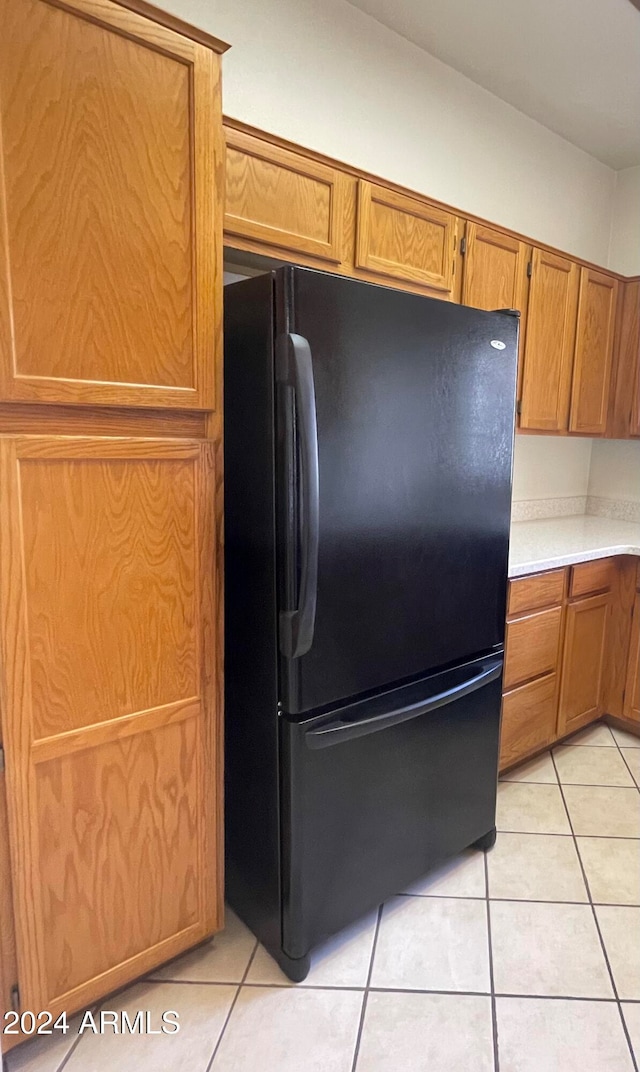 kitchen featuring black fridge and light tile patterned floors