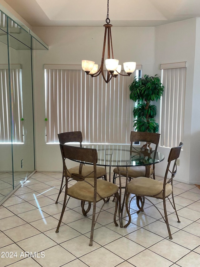 dining space featuring light tile patterned floors and an inviting chandelier