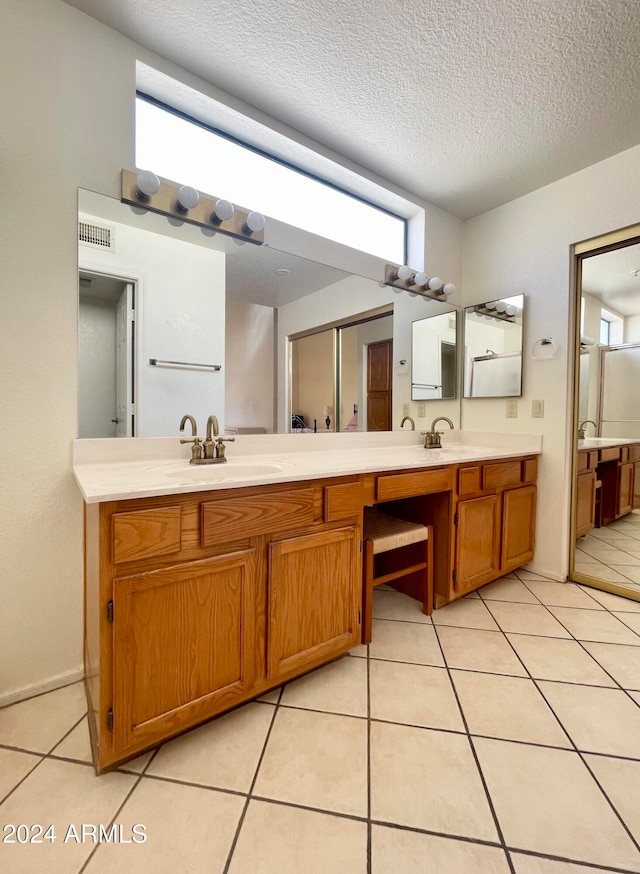 bathroom featuring tile patterned flooring, vanity, and a healthy amount of sunlight