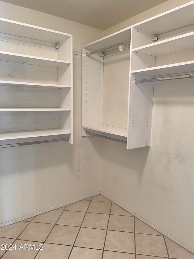 walk in closet with light tile patterned floors