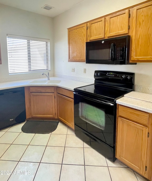 kitchen featuring black appliances, sink, and light tile patterned flooring