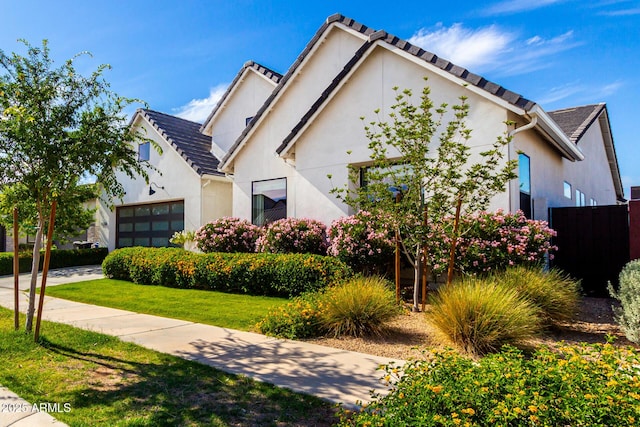 view of front facade with fence, a front yard, and stucco siding