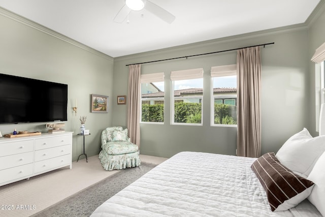 carpeted bedroom with crown molding and a ceiling fan