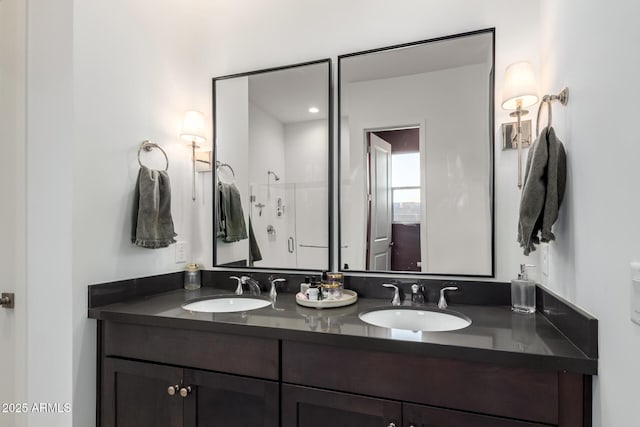 bathroom featuring a sink, a shower, and double vanity