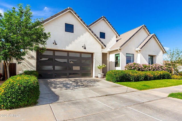 modern farmhouse style home featuring driveway, a tile roof, and stucco siding