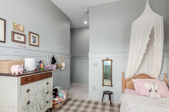 bedroom featuring a decorative wall, recessed lighting, and a wainscoted wall