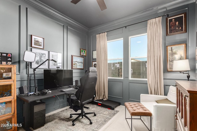 carpeted office featuring ornamental molding, ceiling fan, and a decorative wall