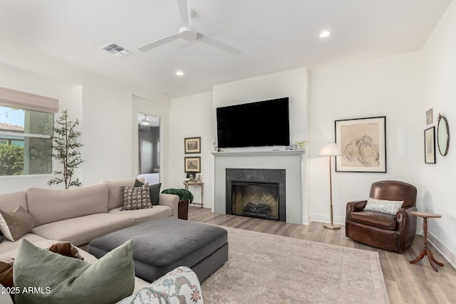 living room with visible vents, a fireplace, ceiling fan, recessed lighting, and light wood-style flooring