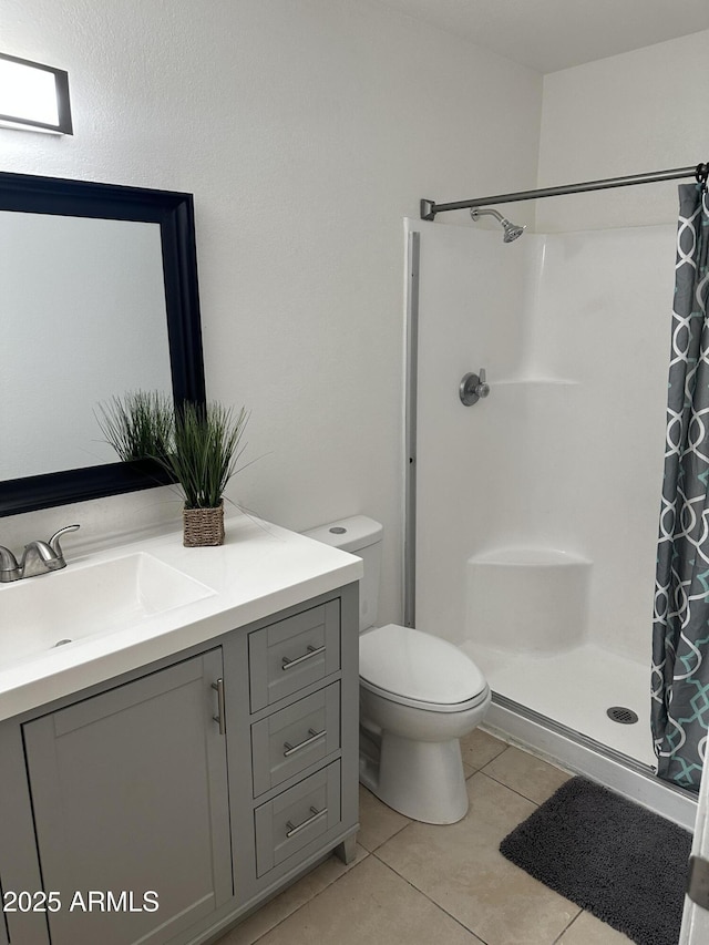 bathroom with tile patterned flooring, vanity, toilet, and a shower with shower curtain