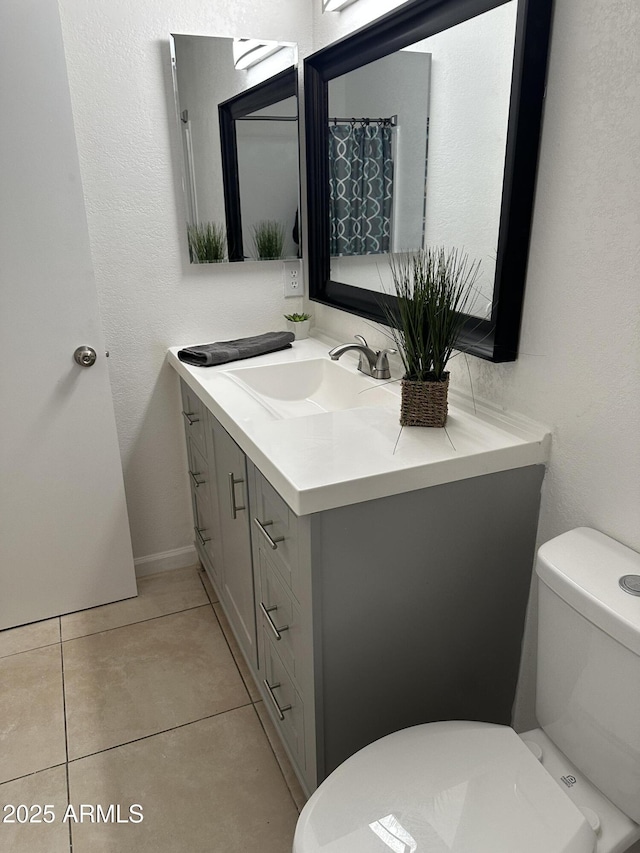 bathroom featuring vanity, tile patterned floors, and toilet