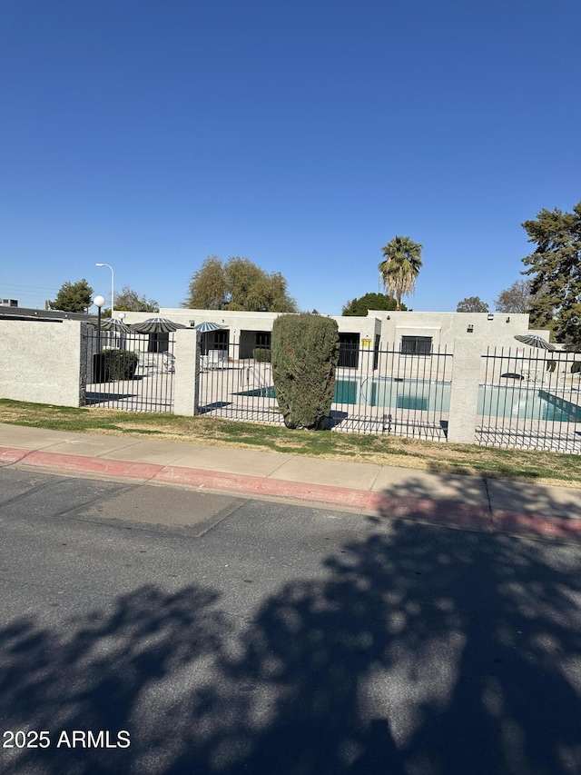 view of gate with a fenced in pool