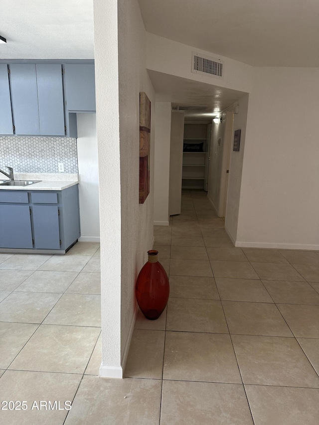 corridor with sink and light tile patterned floors