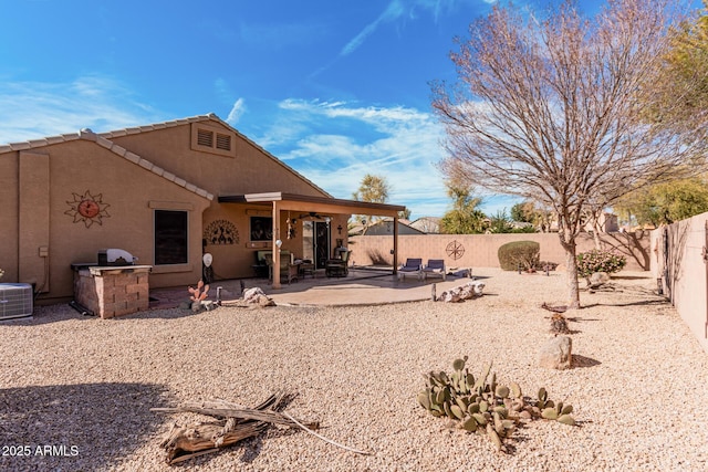 back of property with central AC unit, an outdoor kitchen, a fenced backyard, stucco siding, and a patio area