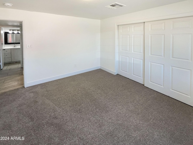 unfurnished bedroom with a closet and carpet