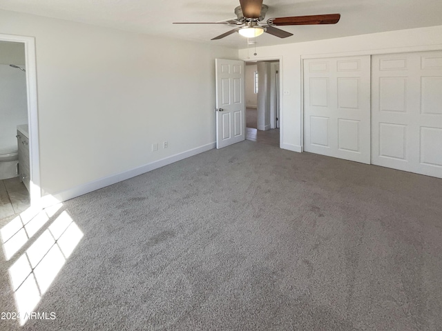 unfurnished bedroom with ensuite bathroom, ceiling fan, light carpet, and a closet