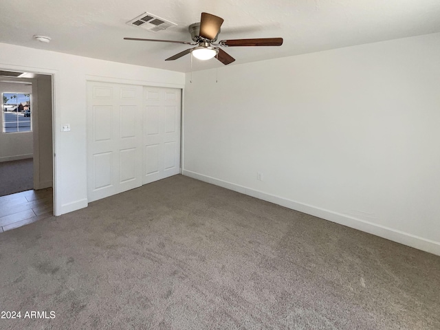 unfurnished bedroom featuring ceiling fan, a closet, and carpet