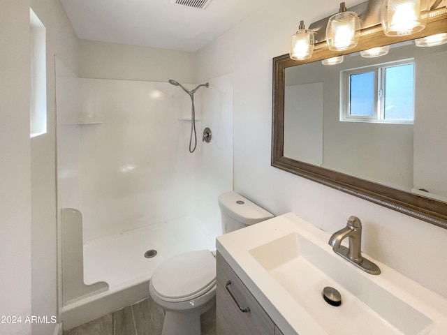 bathroom featuring vanity, toilet, and walk in shower