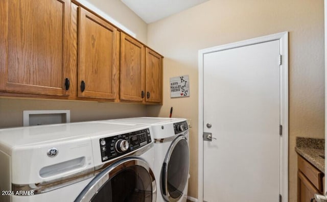 washroom featuring cabinets and washing machine and clothes dryer