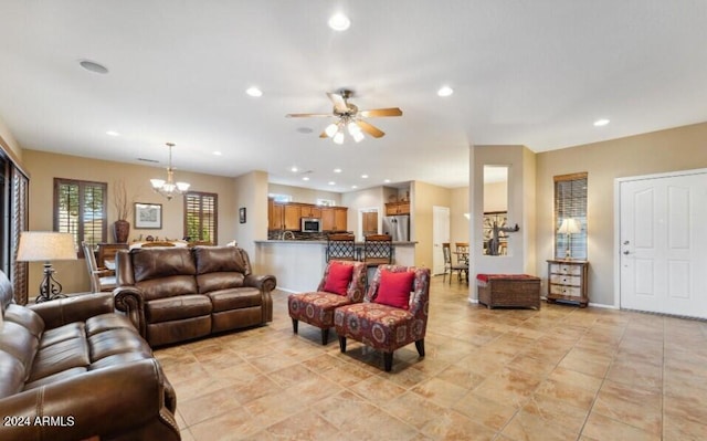 living room featuring ceiling fan with notable chandelier