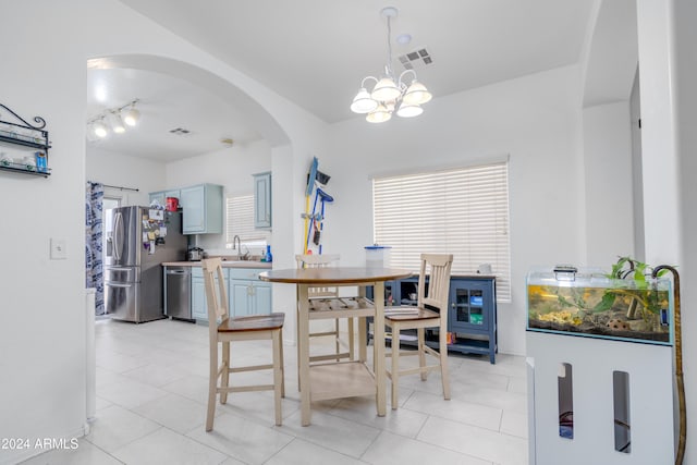 tiled dining room with an inviting chandelier, a healthy amount of sunlight, and sink