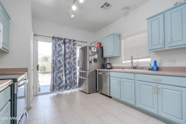 kitchen featuring stainless steel appliances, sink, and light tile patterned flooring