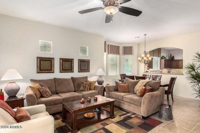 living area featuring light tile patterned floors and ceiling fan with notable chandelier