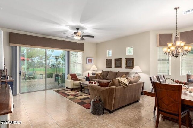 living room featuring light tile patterned flooring, visible vents, and ceiling fan with notable chandelier