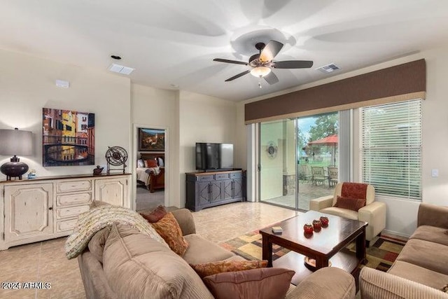 living room with light tile patterned floors, visible vents, and a ceiling fan