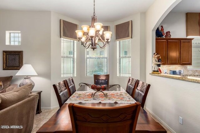 dining area featuring a chandelier, plenty of natural light, and baseboards