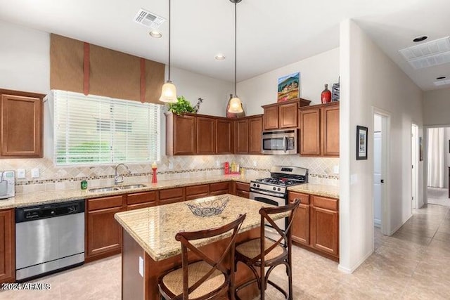 kitchen with light stone countertops, visible vents, appliances with stainless steel finishes, and a sink