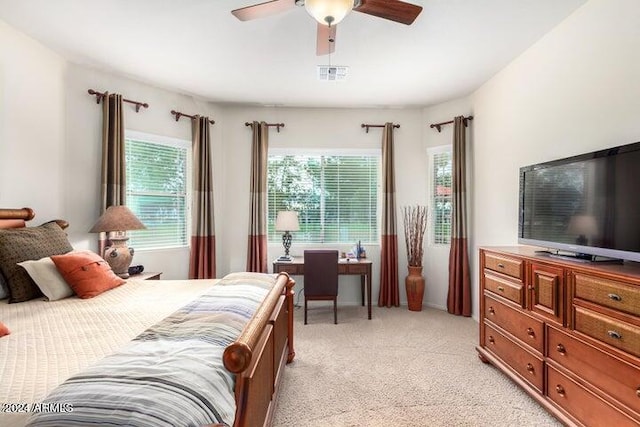 bedroom with visible vents, a ceiling fan, and light colored carpet