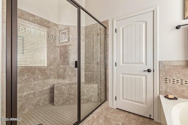 full bathroom with a stall shower, a bath, and tile patterned floors