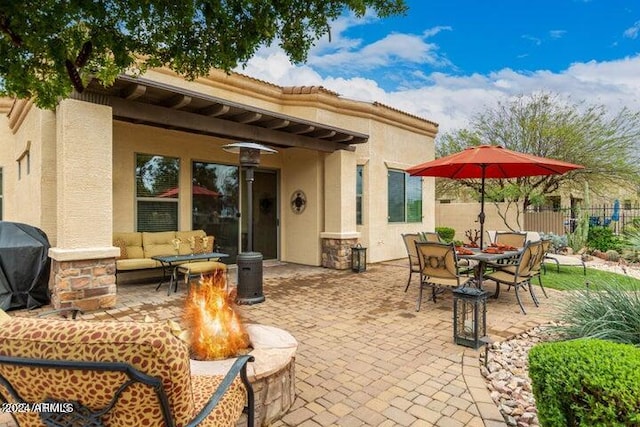 view of patio / terrace featuring an outdoor living space with a fire pit, a grill, and fence